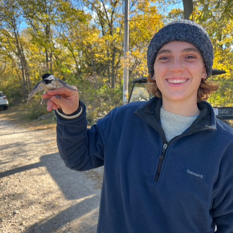 Elena Delach holding a Black-capped Chickadee